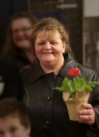 Helen Brown smiling and holding a flower